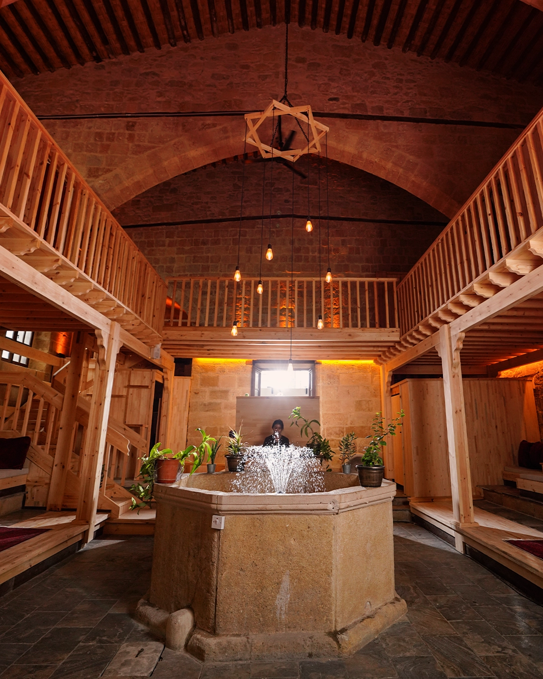 The historic timber galleries, stone arches and central fountain inside Buyuk Hamam